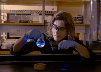 Woman With Gloves Holding Beaker With Uv Light