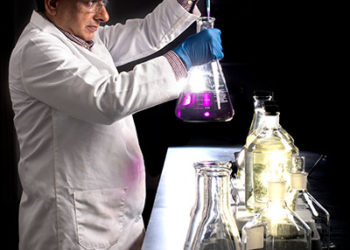 Scientist In Lab Coat Working With Beakers