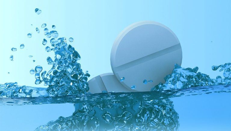 two pills splashing into water