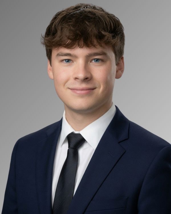 man in a blue suit jacket, white dress shirt and blue tie.